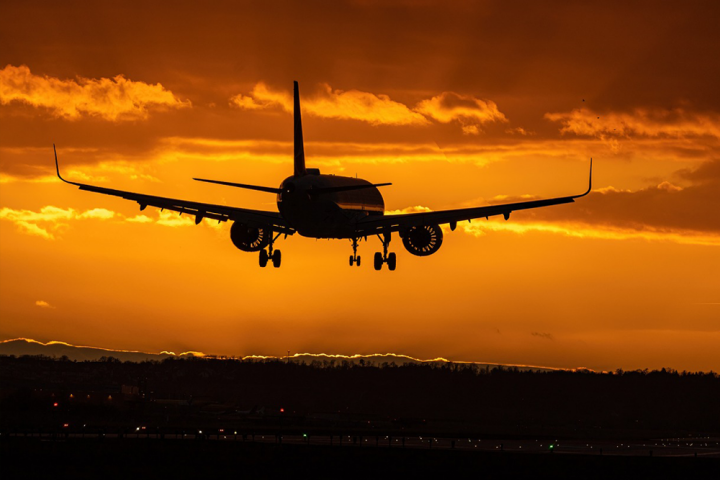 Aeroplane landing on runway at sunset